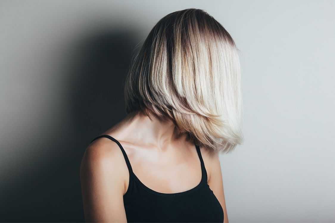 Woman with a chic bob haircut showcasing a blonde ombre style.