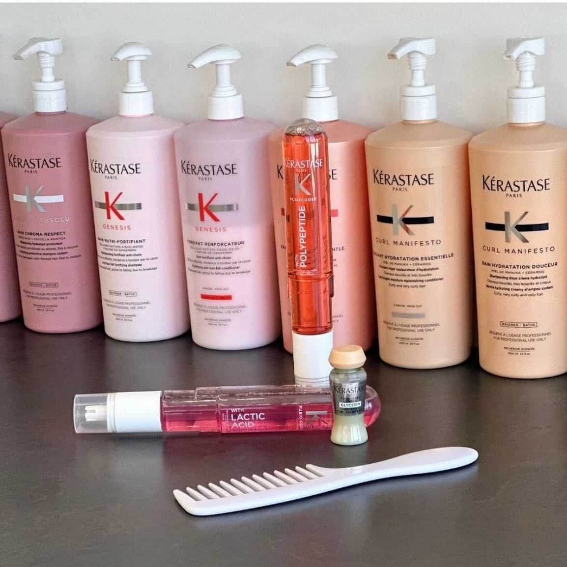 Row of Kérastase hair care products with a brush in front.