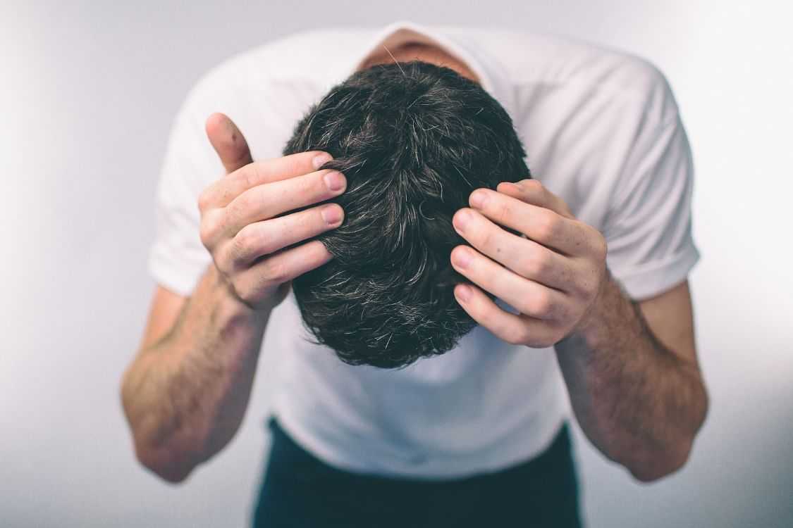 Man holding his head in hands, looking stressed or frustrated.